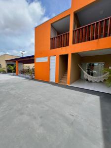 an orange building with an empty parking lot at Chalé Travosa in Santo Amaro