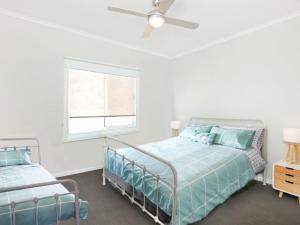 1 Schlafzimmer mit 2 Betten und einem Deckenventilator in der Unterkunft High Tide - Beachfront Pet-friendly in Wallaroo