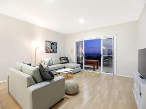 ein Wohnzimmer mit einem Sofa und einem TV in der Unterkunft High Tide - Beachfront Pet-friendly in Wallaroo