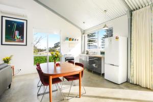 a kitchen with a wooden table and a refrigerator at Pelican Cottage - Pet Friendly - Wifi in Goolwa North