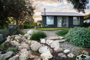 a home with a rock garden in front of a house at Pelican Cottage - Pet Friendly - Wifi in Goolwa North