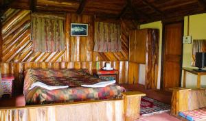 a bedroom with a bed in a wooden room at Mt.Narsing Village Resort in Ravangla