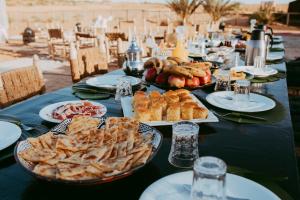 une longue table avec des assiettes de nourriture dans l'établissement Kam Kam Dunes, à Merzouga