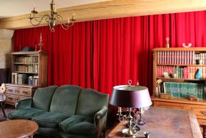 sala de estar con cortina roja y silla en Manoir de Pimelles-Bourgogne-Chablis-2h15 Paris, 