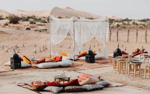 a wedding in the desert with a tent and chairs at Kam Kam Dunes in Merzouga