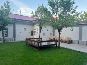 a park bench in a yard with a tree at The Art Hotel by Art Hostel in Yakkasaray