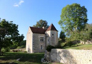 una vieja casa de piedra en una colina con una valla en Manoir de Pimelles-Bourgogne-Chablis-2h15 Paris, 