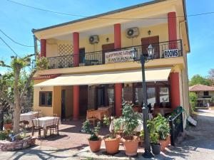 un restaurante con mesas y sillas frente a un edificio en Guesthouse Lithos, en Kalambaka