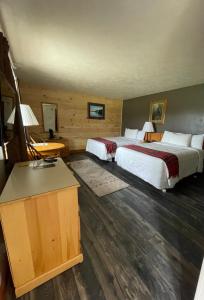 a hotel room with two beds and a desk at Spillover Motel and Inn in Stratton