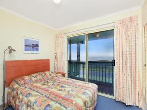 a bedroom with a bed and a large window at Tahren Beachfront Shack Wifi - Pet-friendly in Middleton