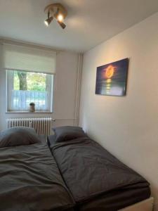 Schlafzimmer mit einem Bett und einem Fenster in der Unterkunft Ferienappartement am Meer in Wilhelmshaven