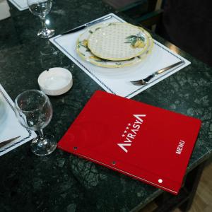 a red book sitting on a table with a plate at Avrasya Hotel in Baku