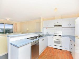 a kitchen with white cabinets and a sink at Tahren Beachfront Shack Wifi - Pet-friendly in Middleton