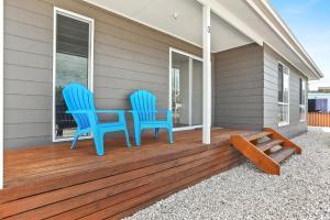 twee blauwe stoelen op de veranda van een huis bij Sa Holiday House 'dunes Views On Simpson' in Goolwa