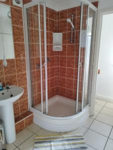 a bathroom with a shower and a sink at lockwood house holiday cottages,Dawlish in Starcross