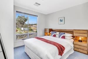 a bedroom with a large bed and a window at The Darling Of Marina - A Hilltop And Sea Getaway in Wirrina Cove