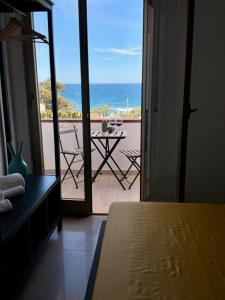 a bedroom with a view of the ocean from a balcony at Appartamenti In Villa Polluce in Fontane Bianche
