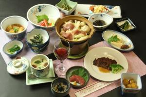una mesa con platos de comida y copas de vino en Andaikan, en Yamanouchi