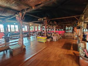 拉瓦格拉Mt.Narsing Village Resort的一间铺着木地板、摆着木桌的大房间