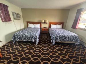 a hotel room with two beds and a carpet at Euclid Motel in Bay City