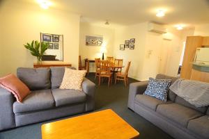Sala de estar con 2 sofás y mesa en The Grand Apartments North Adelaide Parking, en Adelaida