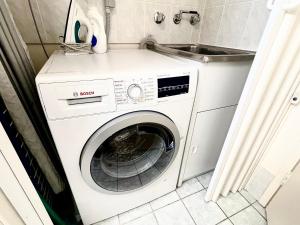 una lavadora en una cocina con fregadero en The Grand Apartments North Adelaide Parking, en Adelaida