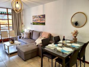 ein Wohnzimmer mit einem Sofa und einem Tisch in der Unterkunft Apartamento Claudia en Lago Santiago in Puerto de Santiago