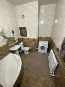 uma casa de banho com um WC, um lavatório e uma máquina de lavar roupa em Квартира 3-ух Комнатная в центре города em Fergana
