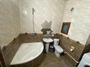 een badkamer met een bad, een toilet en een wastafel bij Квартира 3-ух Комнатная в центре города in Fergana