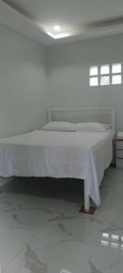 białe łóżko w białym pokoju z białą podłogą w obiekcie MaNelly Guest House Hotel w mieście Donsol