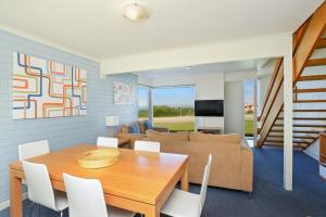 a dining room with a table and a couch at South Seas - Port Elliot Beachfront Apt - Wifi in Port Elliot