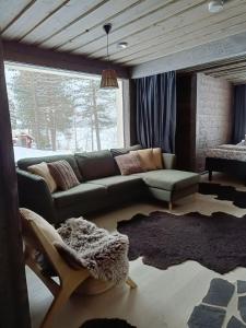 a living room with a green couch and a window at Lapland Hygge in Rovaniemi