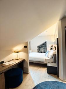 een slaapkamer met een bed en een bureau met een stoel bij Boutique Hotel Sonne Seuzach in Winterthur
