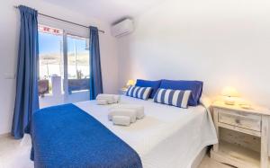 Un dormitorio con una cama azul y blanca y una ventana en Apartamento El Burgado., en Puertito de Güímar