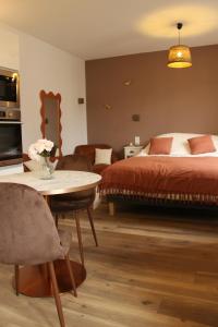 - une chambre avec un lit, une table et des chaises dans l'établissement L'Embellie, à Aix-les-Bains