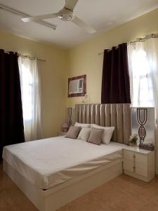 Samhān的住宿－Blossoms hills apartment，卧室配有一张带黑色窗帘的大型白色床