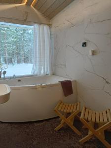 a bathroom with a tub and a sink and a window at Lapland Hygge in Rovaniemi