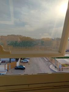 ein Fenster mit Blick auf einen Parkplatz in der Unterkunft Aldar Hotel in Dschāzān