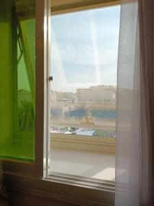 ein Fenster mit Poolblick in der Unterkunft Aldar Hotel in Dschāzān