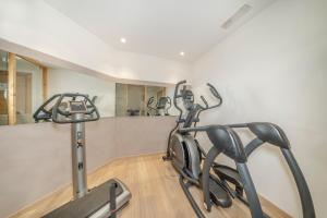 a gym with a treadmill and a mirror at Hotel Chalet Dlaces in Selva di Val Gardena