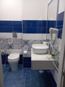 a blue and white bathroom with a toilet and a sink at La Dolce Vita in Naples