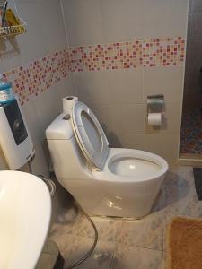 a bathroom with a toilet with the seat up at Sammy Seaview Mae Ramphueng Beach Frontบ้านช้างทองวิวทะเลหน้าหาดแม่รำพึง in Rayong