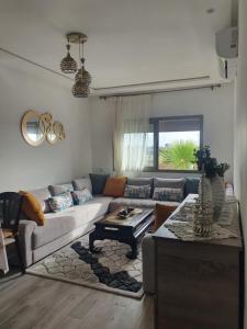 sala de estar con sofá y mesa en HEAVEN BEACH en Sidi Rahal