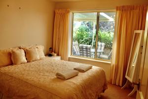 a bedroom with a bed and a large window at 'villa Marie' Pet-friendly Sea Views Beach in Encounter Bay