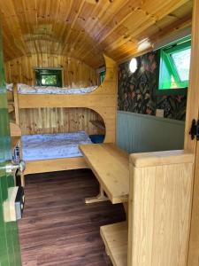a cabin with two bunk beds and a table at Woodie the shepherds hut - sleeps 4 in Chichester