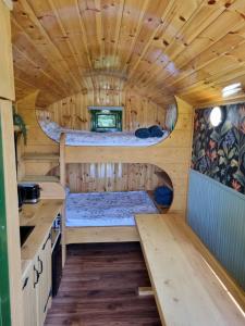una cabaña de troncos con una cama en el medio en Woodie the shepherds hut - sleeps 4, en Chichester