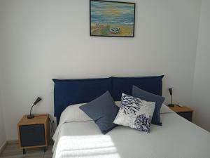 パレルモにあるLa casetta di rosario mondelloのベッド(青いヘッドボード、枕付)