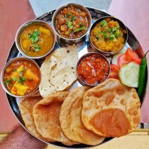 um prato de comida com pão pita e vários mergulhos em Hotel Kashyaam Inn em Varanasi