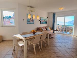 a living room with a table and a couch at Haus Mit Meerblick in Lopar