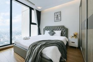 ein Schlafzimmer mit einem großen Bett und großen Fenstern in der Unterkunft Lynn Housing- Vinhomes Metropolis- LUX. Apartment system in Hanoi